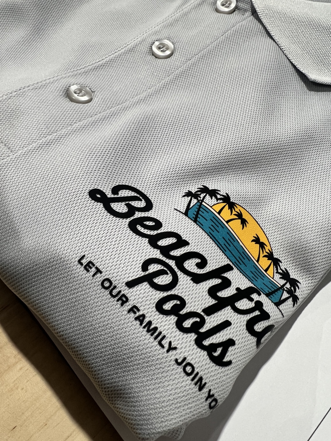Full-color Beachy Pools logo printed on a gray polo shirt
