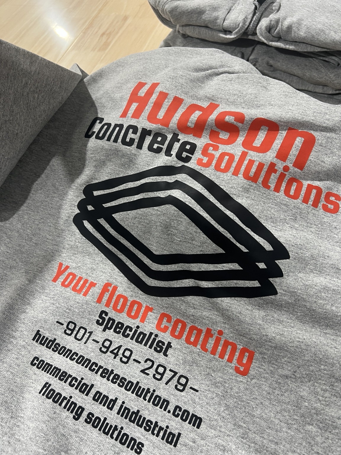 Hudson Concrete Solutions logo printed on a gray shirt