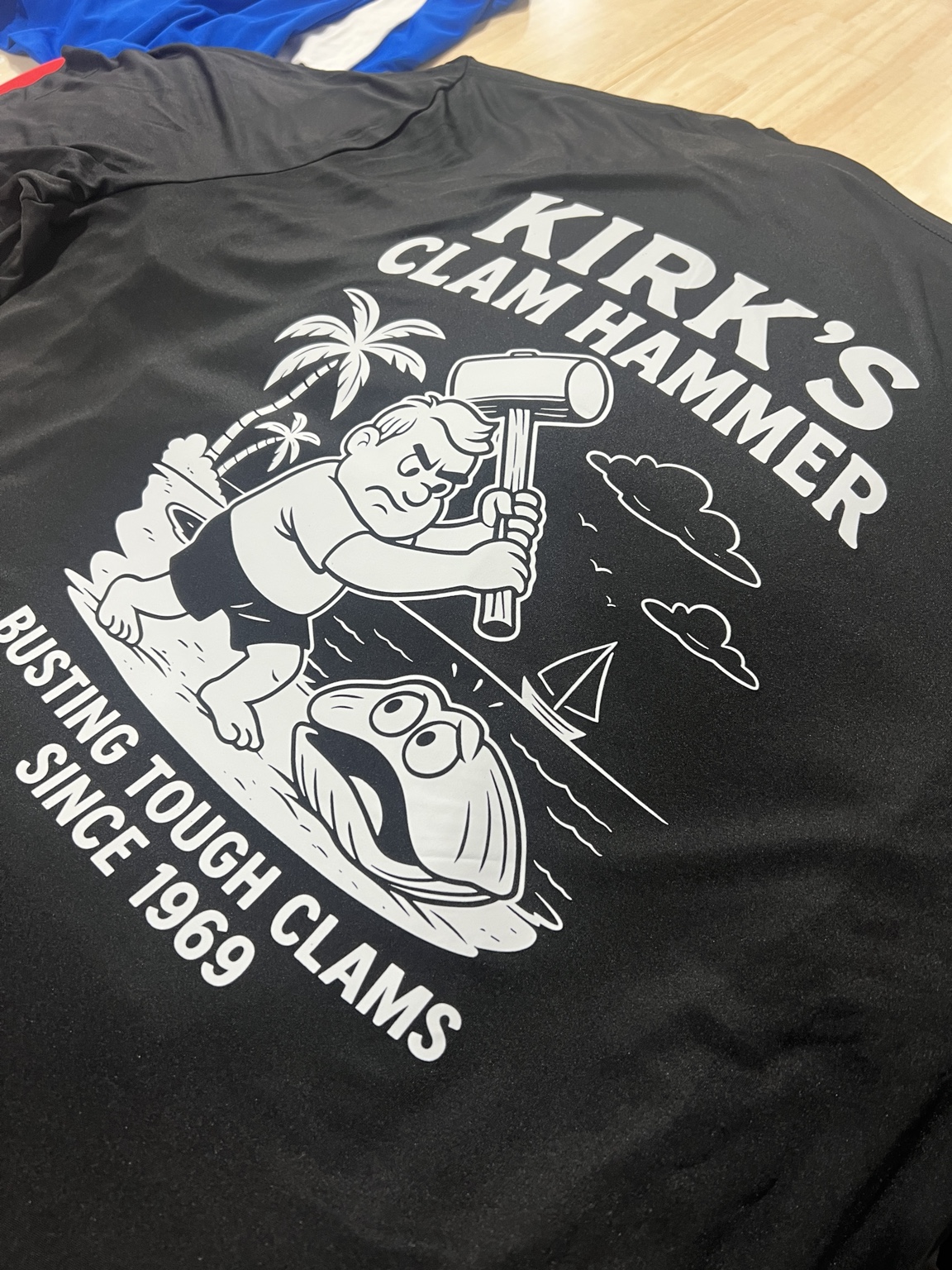 Large white Kirk's Clam Hammer graphic printed on a black shirt
