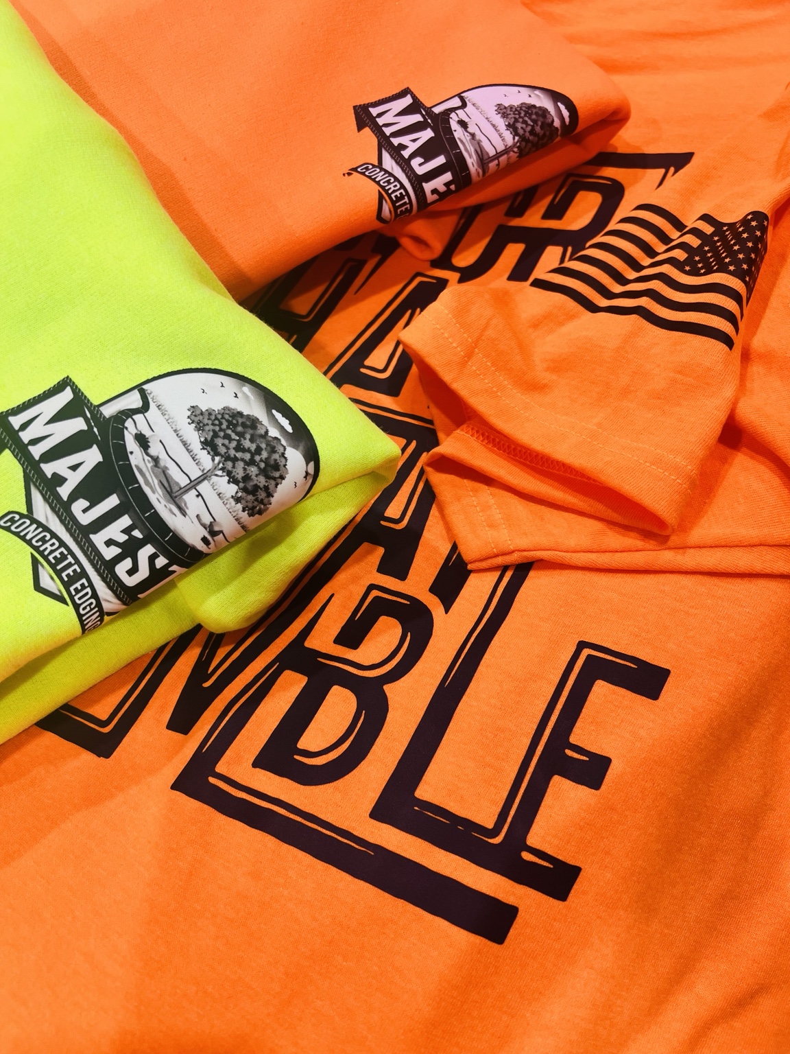Safety orange and yellow shirts with black printed logos