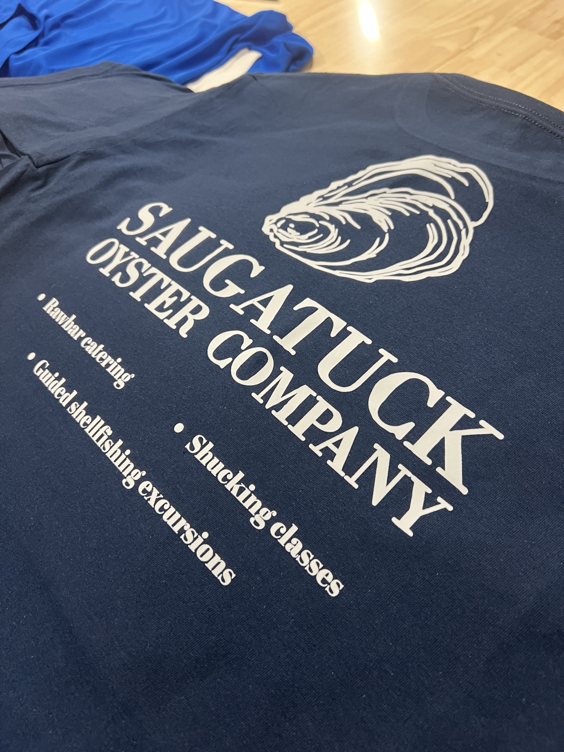 White Saugatuck Oyster Company back print on navy apparel